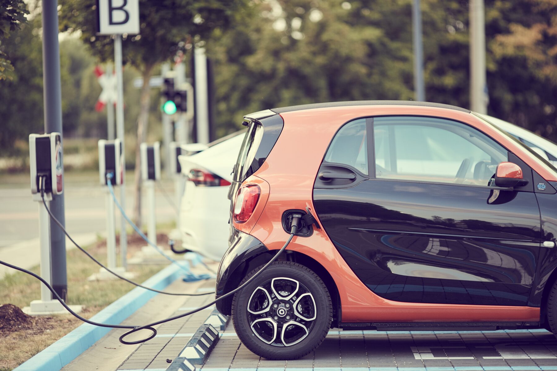 Electric vehicle parked at a charging station on an asphalt parking lot designed for EV infrastructure