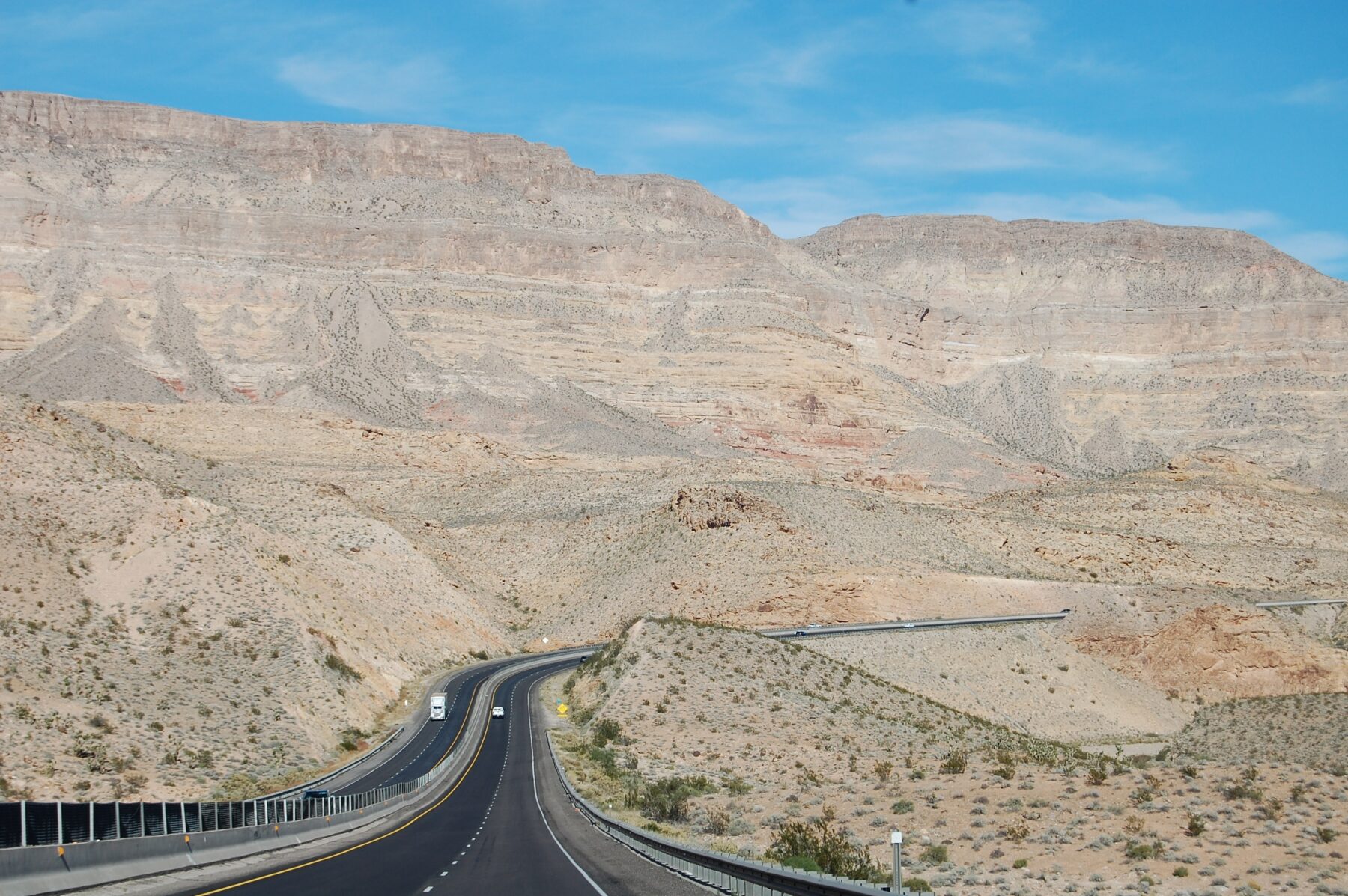 Asphalt highway under sunny conditions showing how heat exposure affects pavement performance and lifespan