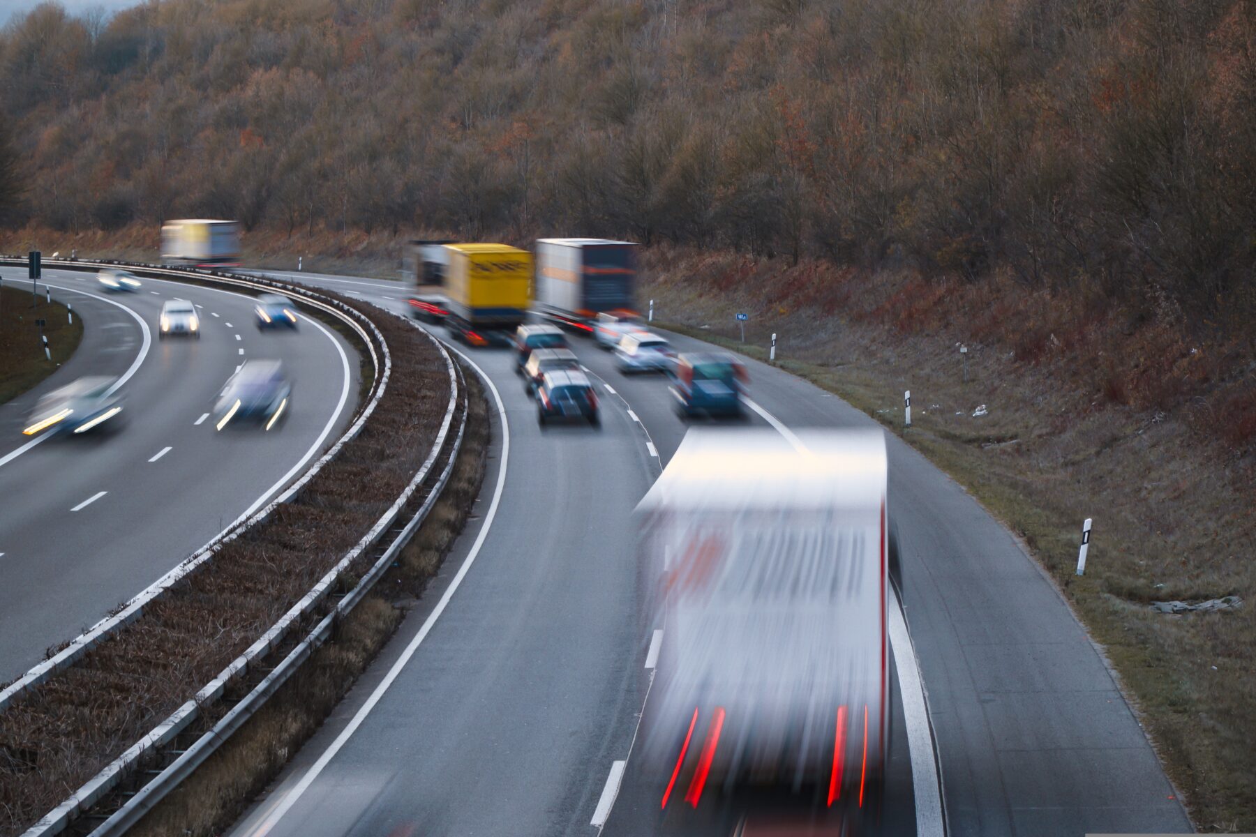 Highway traffic on asphalt road showing heavy vehicle use that can worsen cracks and pavement damage in summer